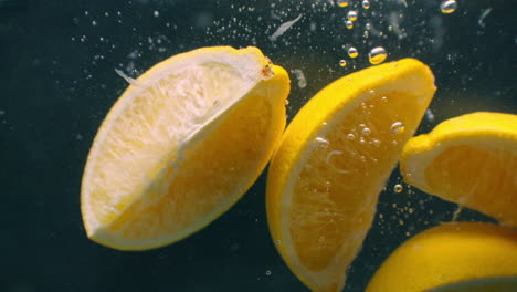 Mehrere-Zitronenfrüchte-Fallen-In-Einen-Wassertank-Und-Stören-Das-Wasser.-Drei-Leuchtend-Gelbe-Zitronenfrüchte-Fallen-In-Einen-Wassertank-Und-Kehren-An-Die-Oberfläche-Zurück